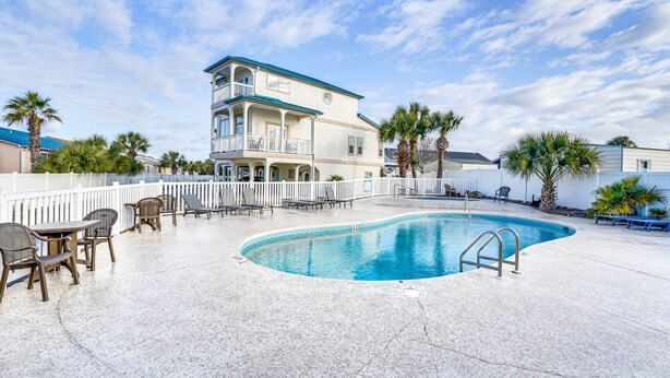 A pool area with lounge chairs and a two-story building with balconies. - Renovated PCB Studio, 2 Min Walk To Laguna Beach! (Panama City Beach)