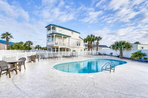A pool area with lounge chairs and a two-story building with balconies. - Renovated PCB Studio, 2 Min Walk To Laguna Beach! (Panama City Beach)