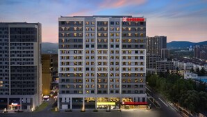 Un hôtel à plusieurs étages, doté d’une façade moderne, de nombreux balcons et d’une enseigne bien visible indiquant qu’il s’agit d’un Hilton Garden Inn.