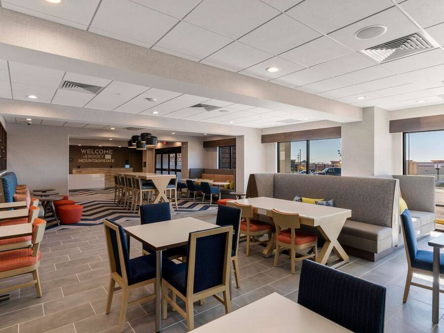 A modern hotel lobby with a reception area, seating arrangements, and large windows offering a view.