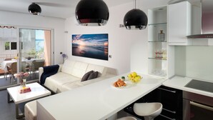 A modern kitchen with a white countertop, black cabinets, and a large window. - Sun Spalato Suite (Makarska)