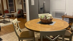 A modern kitchen with a round wooden table, two chairs, a refrigerator, and a dining area with a rug. - Cheerful Downtown 3 Bedroom home in the historic area of Columbus (Columbus)