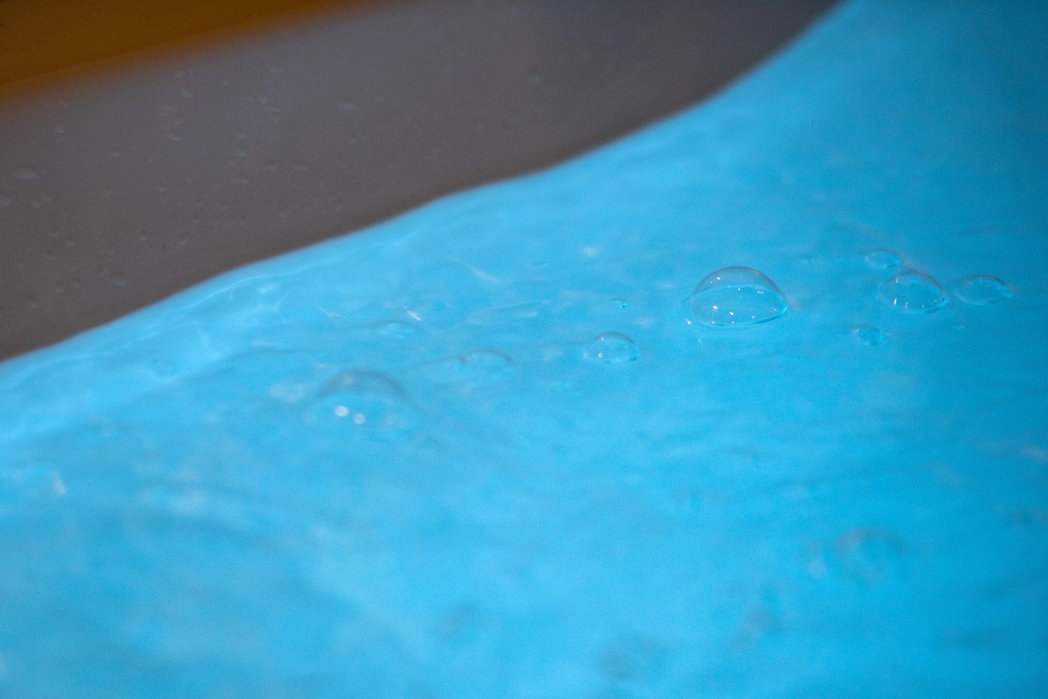 A close-up of a blue surface with water droplets.
