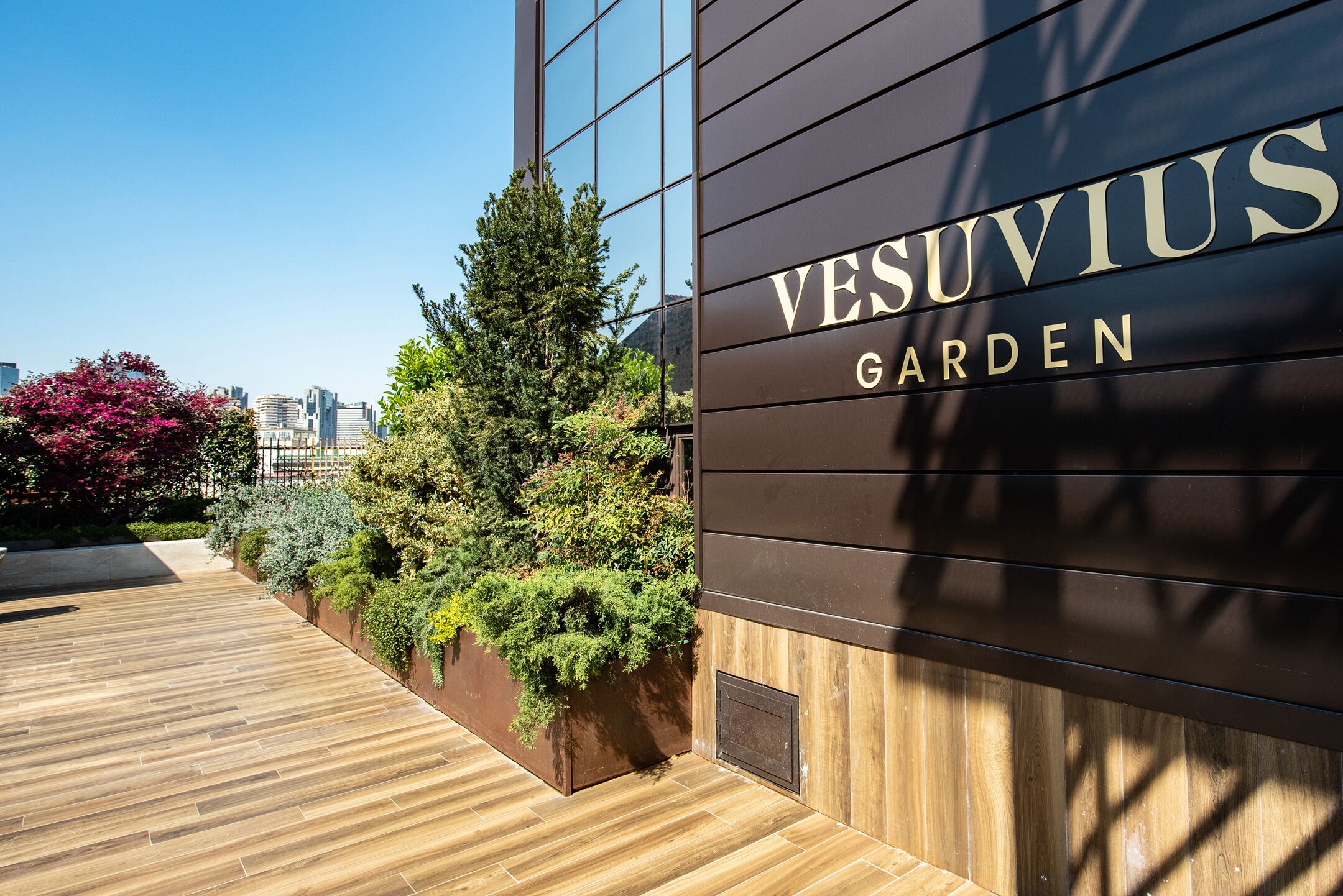 Ein modernes Gebäude mit der Aufschrift "VESUVIUS GARDEN" an der Fassade.