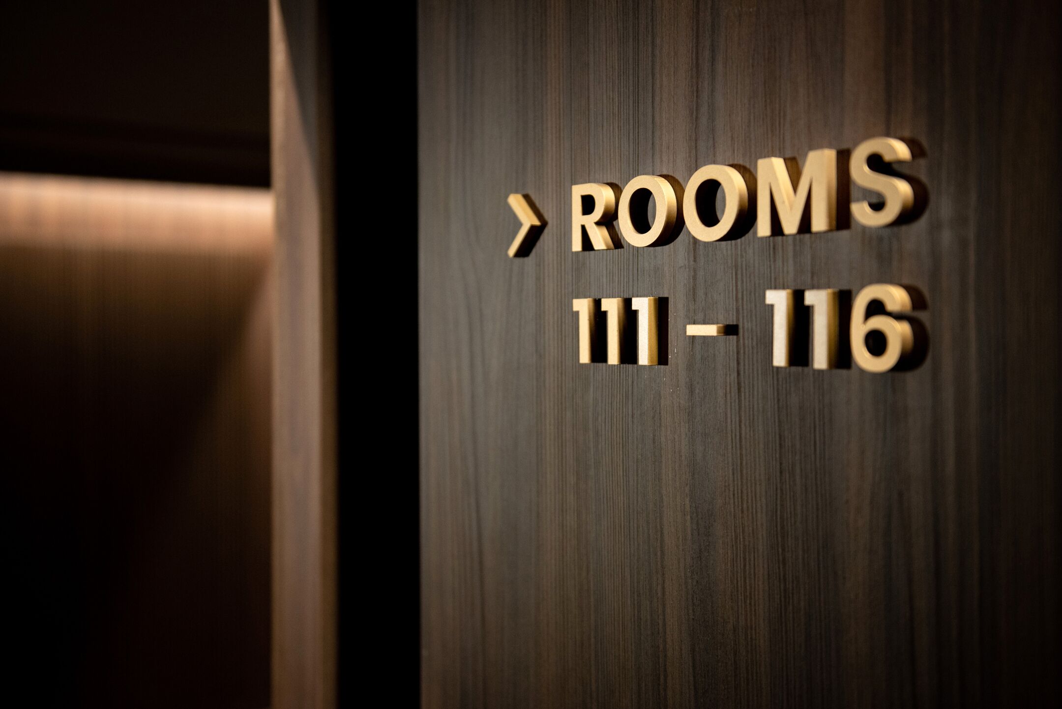 A sign indicating rooms 111-116.