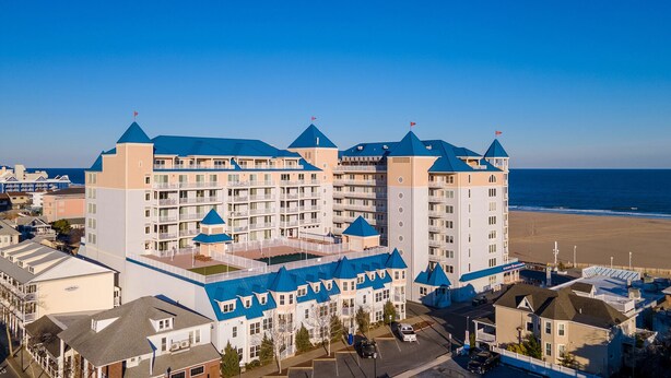 Ein großes Hotel mit mehreren Türmen, Blick auf den Strand und einem Parkplatz.