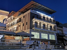 Un hotel de varios pisos con balcones y terraza.