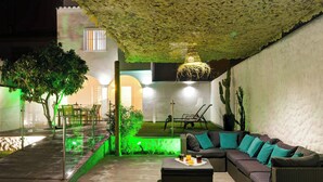Un espacio exterior moderno con sofá, mesa de centro y comedor.