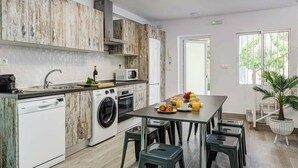 Una cocina moderna con una isla central, electrodomésticos integrados y un comedor con taburetes.