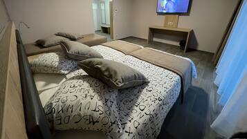 Habitación cuádruple Confort | Ropa de cama de alta calidad y camas con efecto memoria