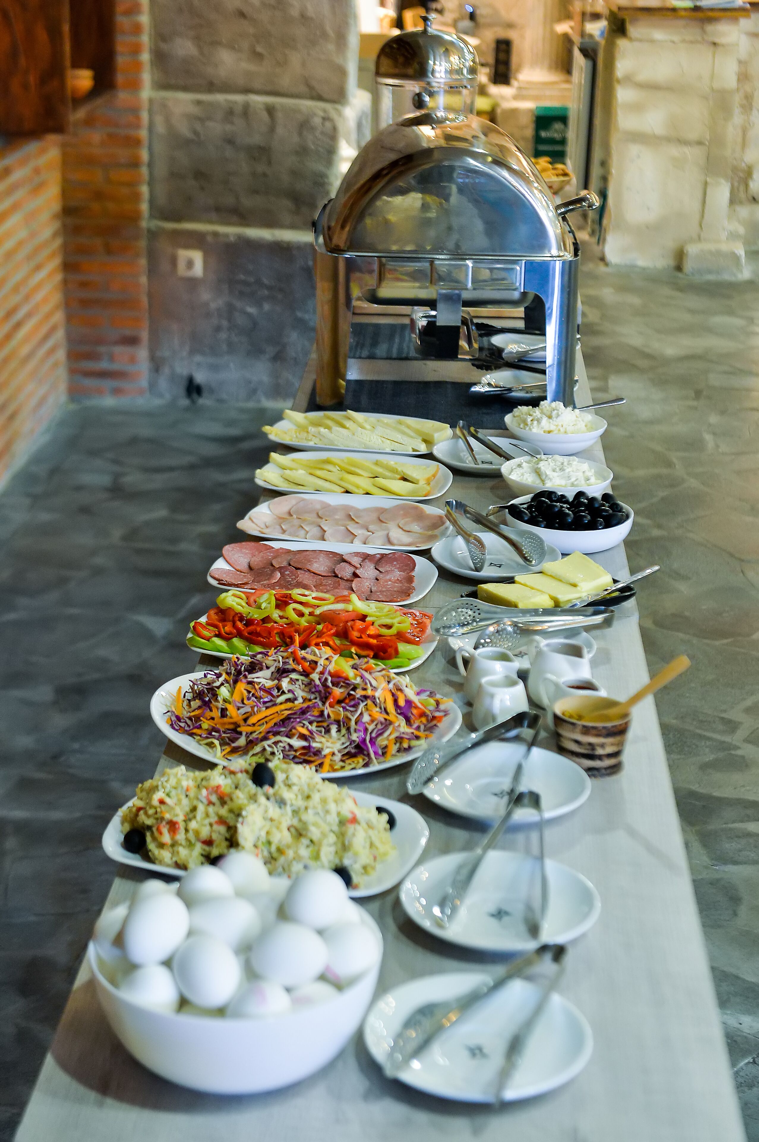 A buffet table with various dishes and a coffee urn.