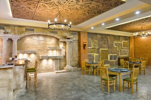 Un restaurante con chimenea de piedra, mesas y sillas de madera.