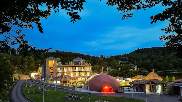 Un hotel con un edificio grande, una estructura en forma de cúpula y una carretera curva.