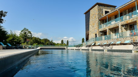 Una piscina al aire libre de temporada, sombrillas