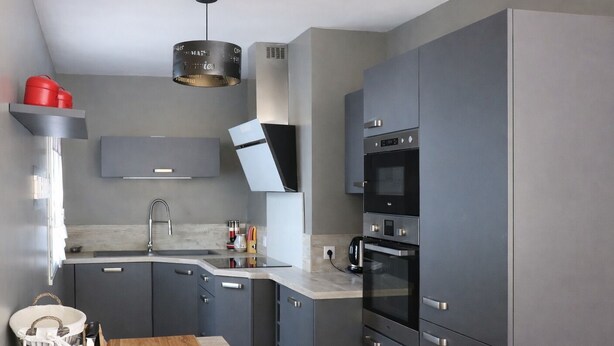 A modern kitchen with grey cabinets, a built-in oven, and a wooden countertop. - House TELLINE      . (Saint-Martin-de-Ré)