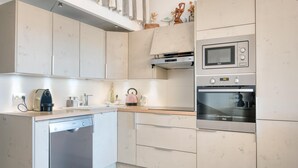 A modern kitchen with a dishwasher, microwave, and oven. - Appartment PERTUIS . (Saint-Martin-de-Ré)
