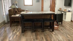 A dining area with a wooden bench, a table, and a television.