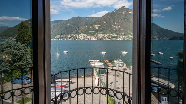 A balcony with a view of a lake, boats, and a mountainous landscape. - Suite "Anguilla" at 2 steps from the lake with panoramic view. Lounge bar and swimming pool (Faggeto Lario)