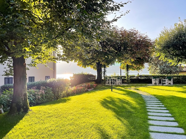 Un jardin bien entretenu, avec un chemin de pierres menant à un espace aménagé pour s’asseoir.