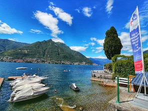 A lake with boats docked, a pier, and a mountain in the background. - "Lavarello" Suite, just a stone's throw from the lake, with a private outdoor seating area, lounge bar, and pool (Faggeto Lario)