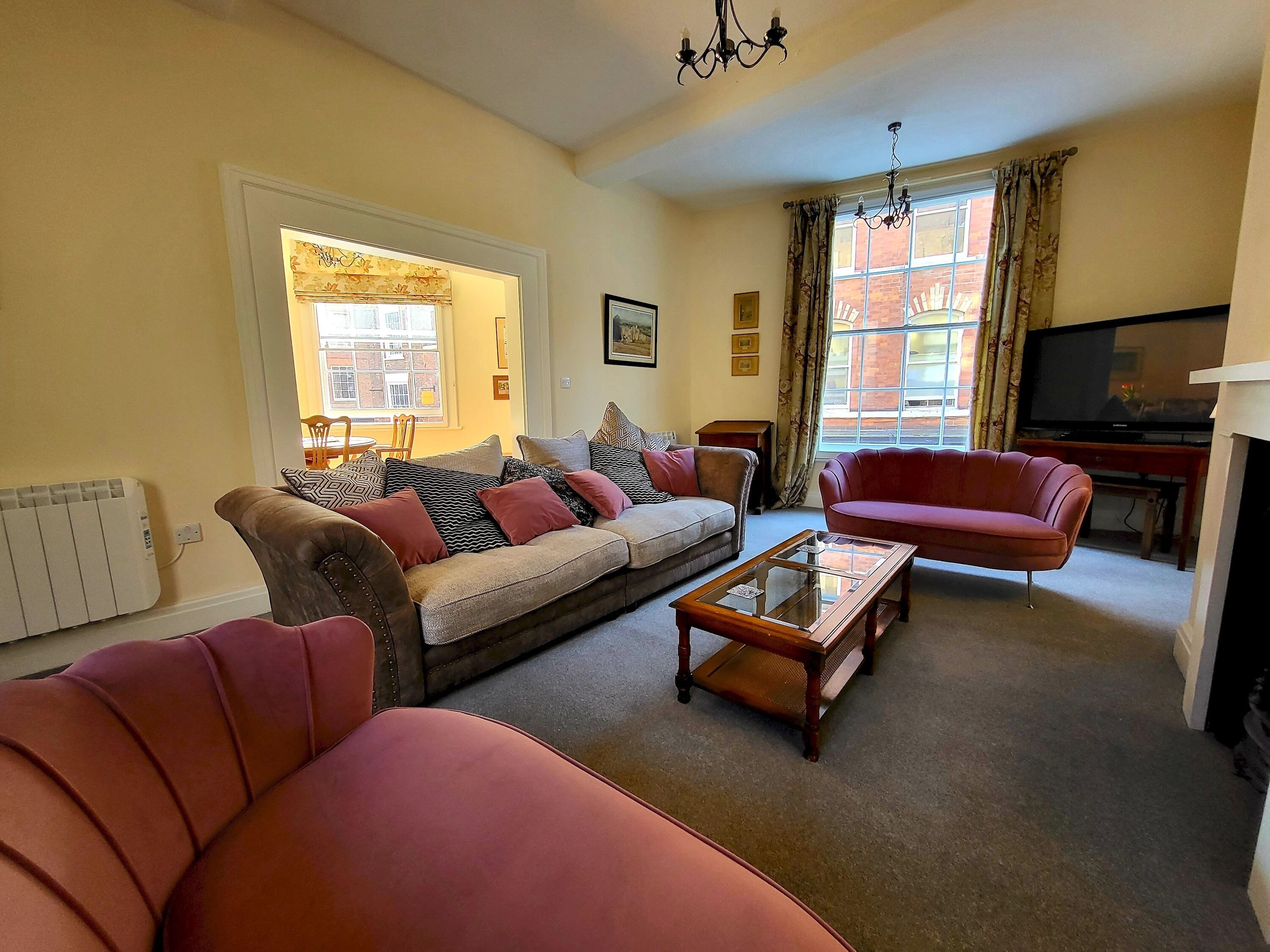 A living room with a sofa, armchairs, a coffee table, and a television.
