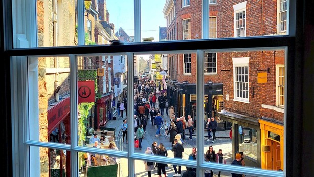 Ein belebter Straßenblick durch ein fenster mit mehreren Glasscheiben.