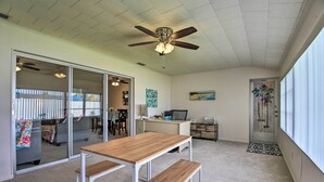 A spacious room with a ceiling fan, a wooden table with benches, a desk, and a computer. - Pool Access: Ranch-Style House in Sun City Center (Sun City Center)
