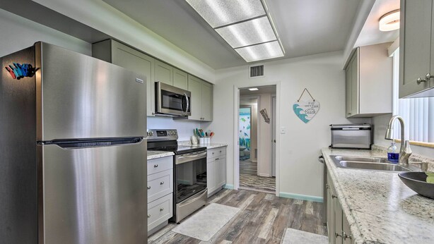 A modern kitchen with stainless steel appliances, a microwave, and a built-in oven. - Pool Access: Ranch-Style House in Sun City Center (Sun City Center)