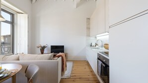 Eine moderne Küche mit weißen Schränken, einer Holz Arbeitsplatte und einem eingebauten Backofen.