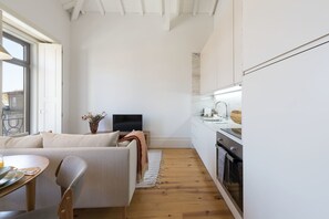 A modern kitchen with white cabinets, a wooden countertop, and a built-in oven.