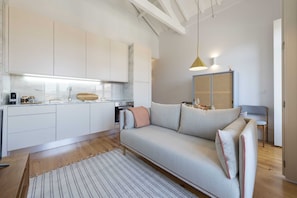 A modern kitchen with white cabinets, a wooden countertop, and a built-in oven.
