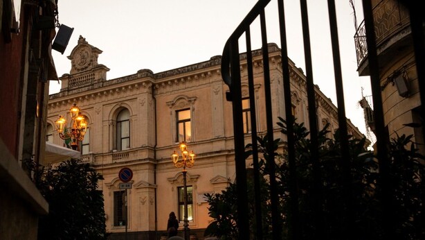 A historic building with ornate architecture, a no parking sign, and a well-lit entrance. - Agora Holiday House (Palazzolo Acreide)