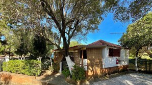 A small, single-story building with a tiled roof, surrounded by trees and gravel. - Blue Med Bambi, Palinuro, Cilento (Palinuro)