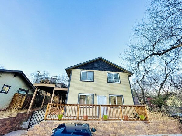 A two-story house with a balcony, a garage, and a driveway.