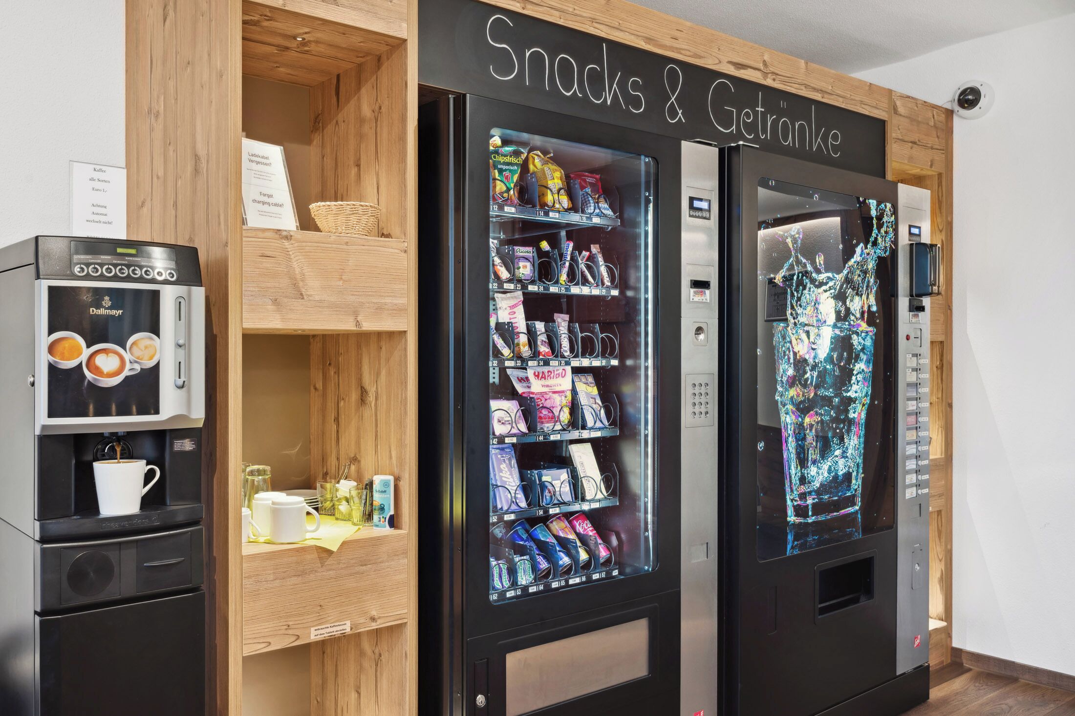 A vending machine area with snacks and drinks, a coffee machine, and a refrigerator.