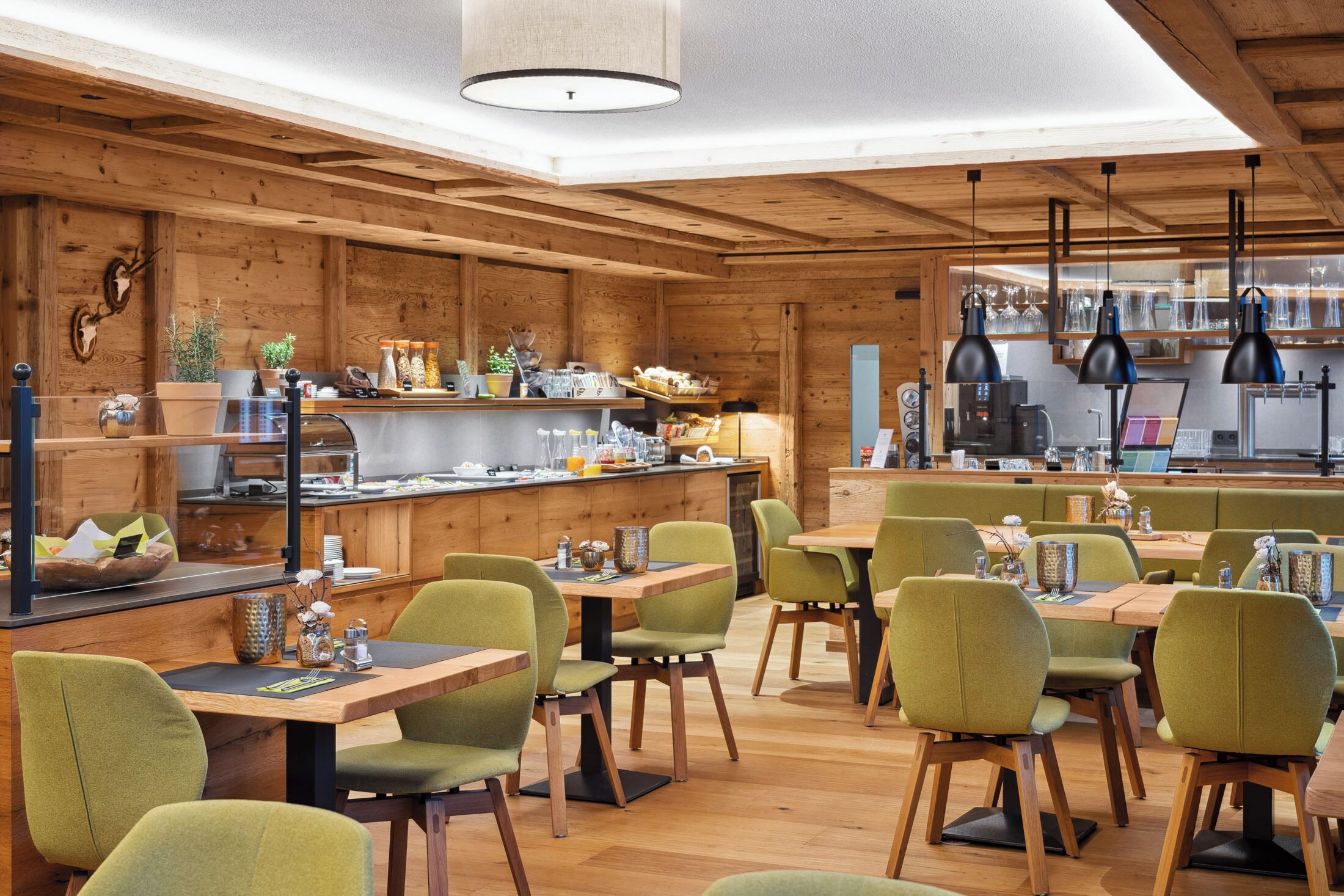 Un intérieur en bois comprenant un bar, des espaces pour s’asseoir et une cuisine.
