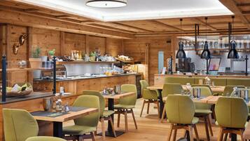 Un interior de madera con una zona de bar, asientos y una cocina.