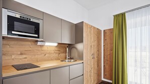Una cocina moderna con horno integrado, un lavamanos y armarios de madera.