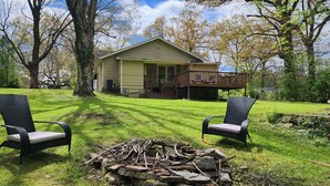 A house with a porch, two wicker chairs, and a pile of firewood. - Red Bud (Chattanooga)