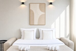 Habitación de hotel con una cama, dos mesitas de noche, una obra de arte en la pared y una ventana.