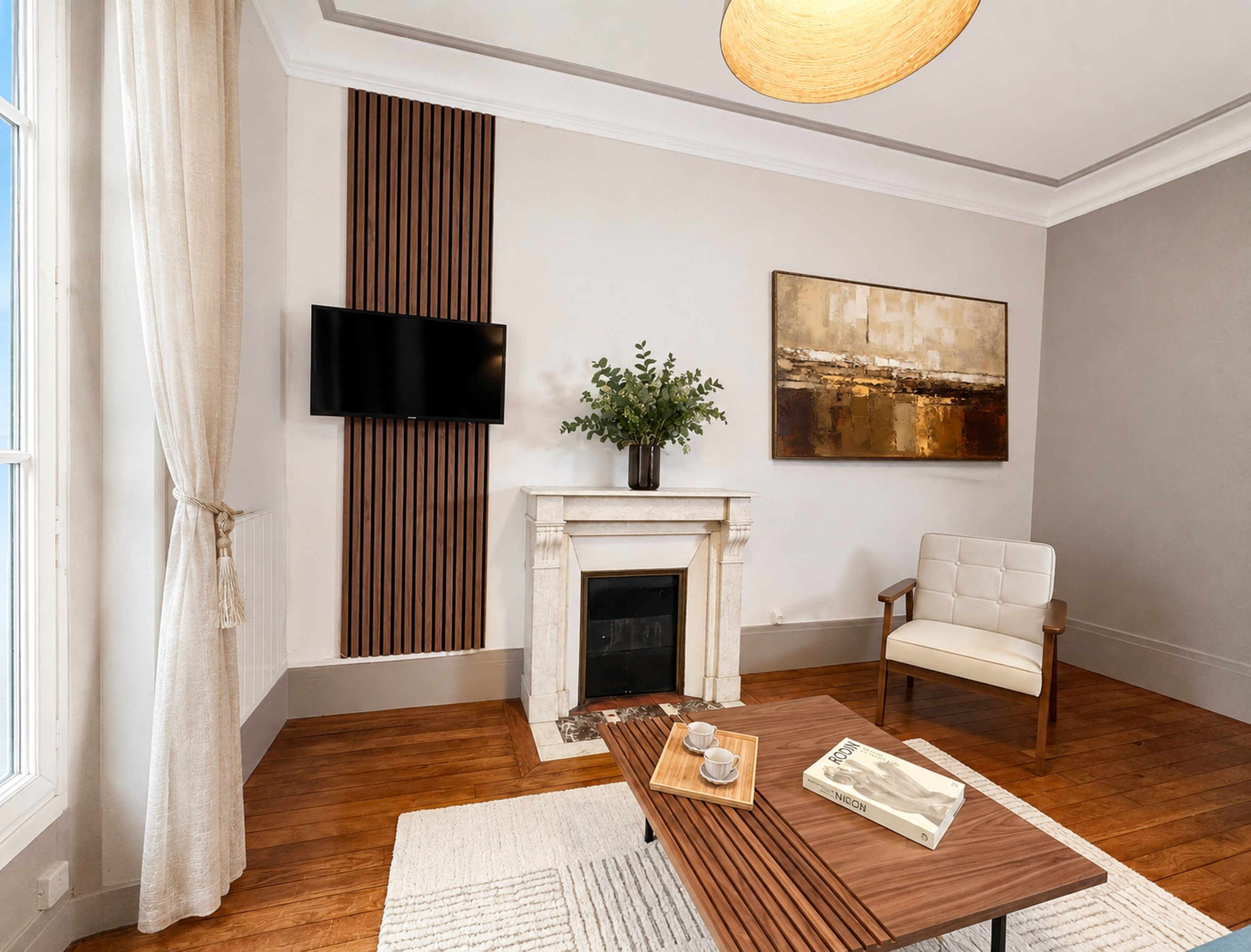 Una sala de estar con chimenea, televisor montado en la pared, sofá y mesa de centro con bandeja.