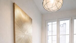 A dining area with a round table, chairs, and a window with a view. - Charming flat with lift - Eiffel Tower (Paris)