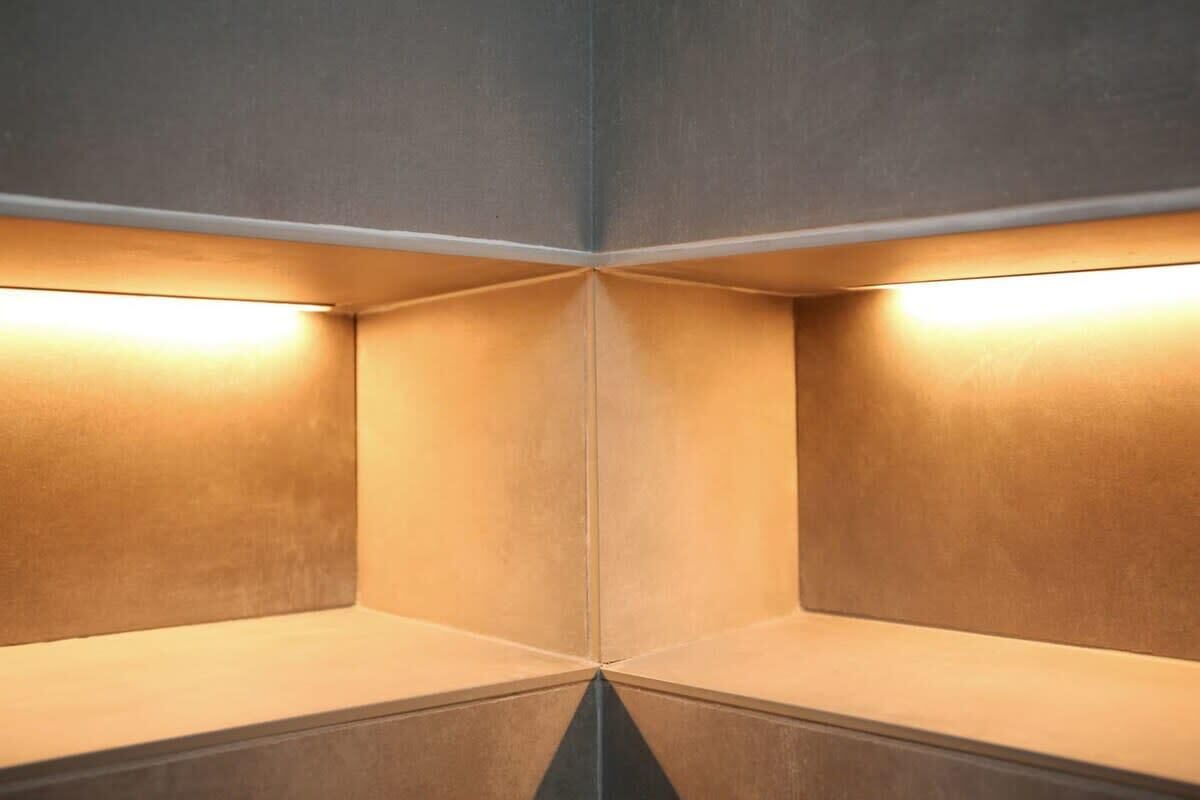 A corner of a room with a mirrored wall and a light fixture.