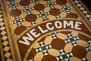 Ein Mosaikboden mit der Aufschrift 'WELCOME'.