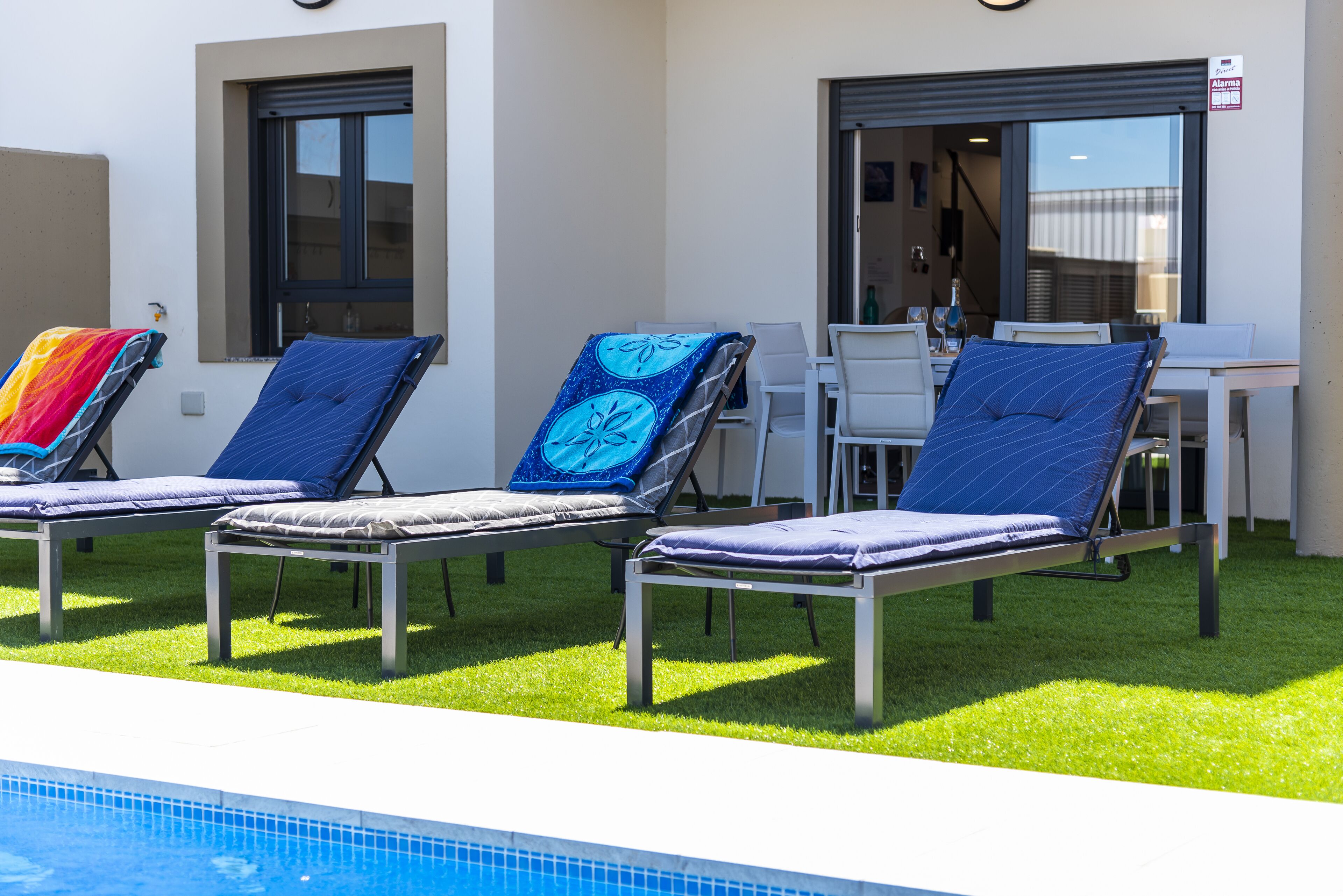 Een buitenzwembad, een verwarmd zwembad, ligstoelen bij het zwembad