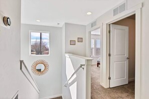Enter a serene space with a door leading to another room, featuring a window and a decorative mirror.