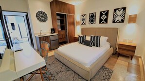 A bedroom with a bed, desk, chair, and a wardrobe. - Bahay By Riviera Rentals (Playa del Carmen)