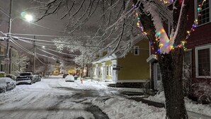 A snow-covered street with houses on either side, decorated with colorful lights. - Heritage Row House beside Citadel Hill (Halifax)