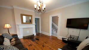 Ein Wohnzimmer mit Kamin, Treppe und Flachbildfernseher.