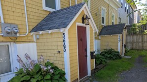 Une maison jaune avec une porte rouge et le numéro 5665.
